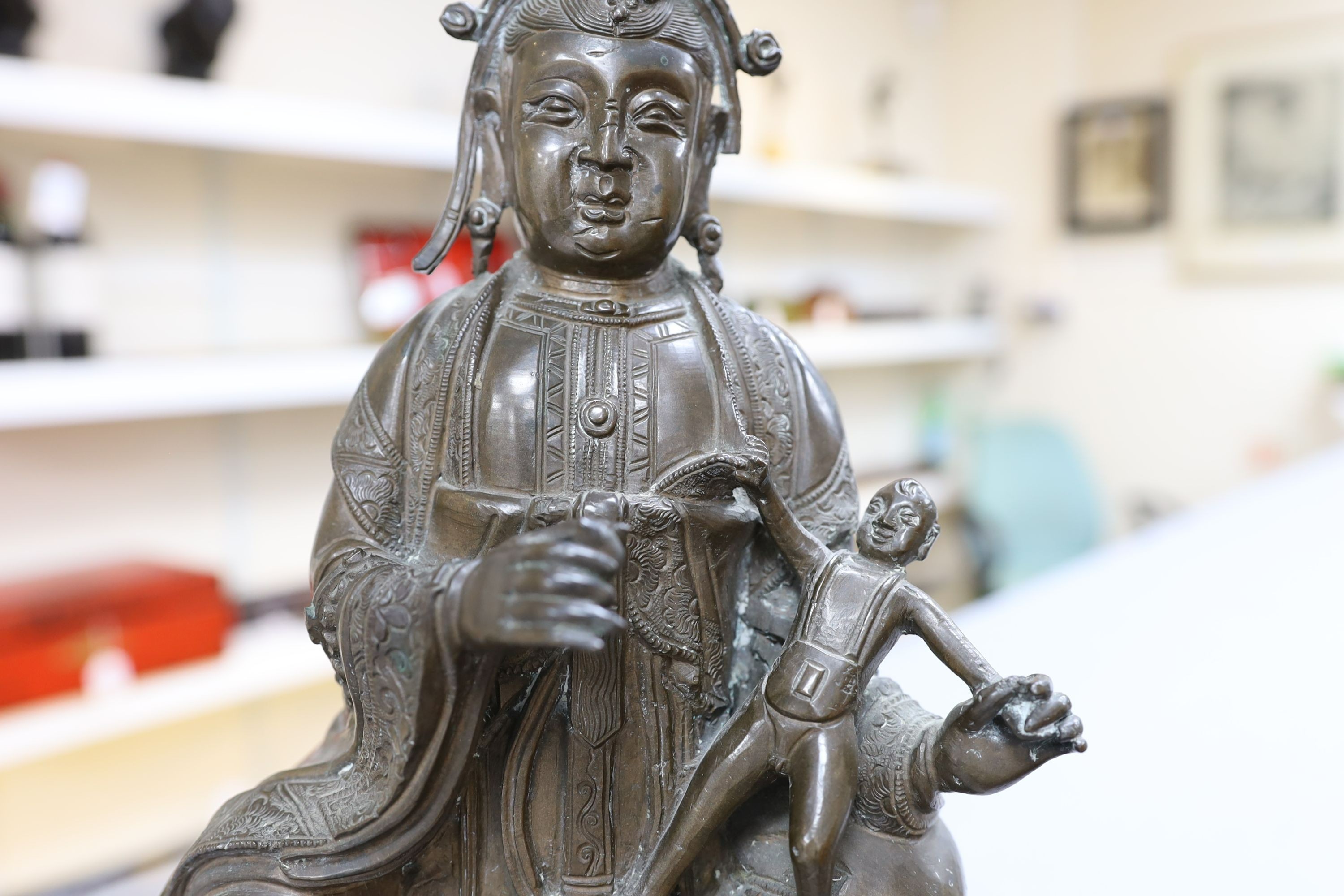 A large Chinese bronze group of Xi Wangmu and a child, late Ming dynasty, 31.5cm high excluding later wood stand